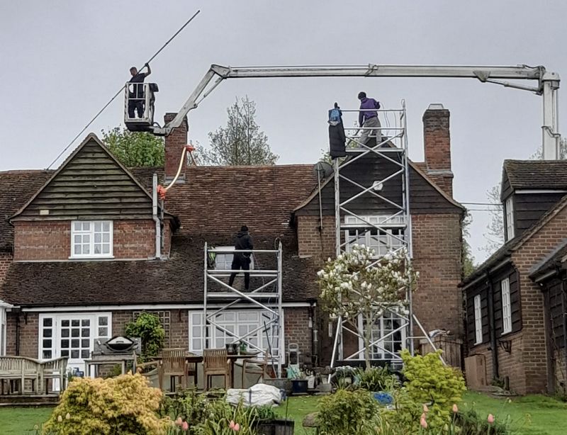 The Moss Cleaners using cherry picker and scaffolding to clean roof safely and professionally in Weybridge, Surrey